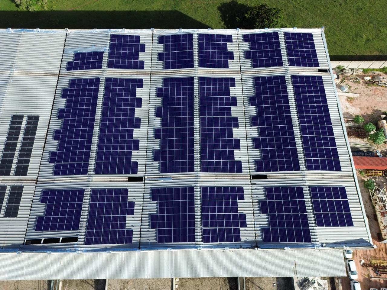 Painéis solares cobrindo o telhado metálico de um galpão industrial